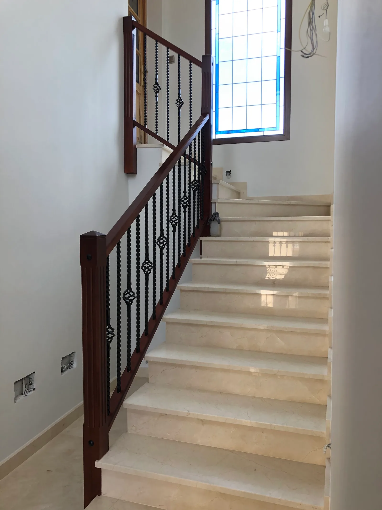 Escalera de mármol con barandilla de madera y forja